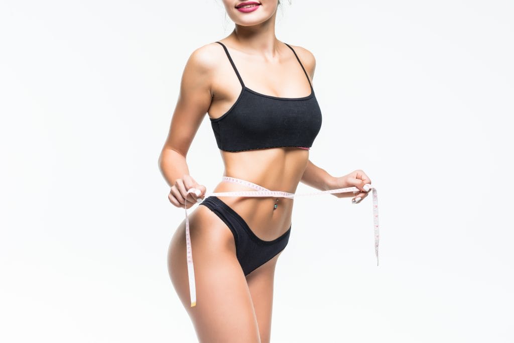 Woman in the black underwear measuring her waist with meter tape.